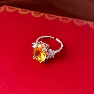 Detailed view of an adjustable silver ring with a vibrant yellow oval gemstone.