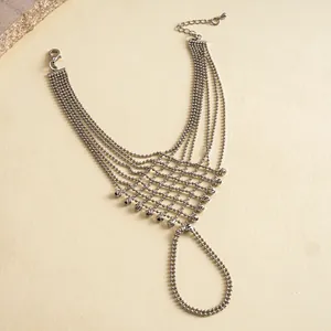 Close-up of silver-colored metal bead hand chain with intricate mesh and tassel design