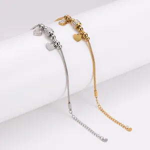 Detailansicht von Herzanhänger Schlangenkette Armbändern in Gold und Silber Tönen