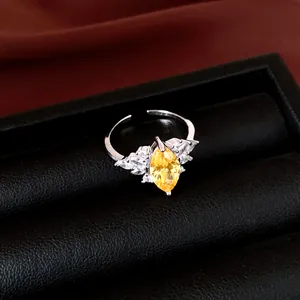 Detail van een zilveren verstelbare ring met een sprankelende gele marquise geslepen zirkoon