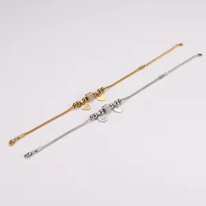 Detailansicht von goldenen und silbernen Edelstahl-Schlangenarmbändern mit Kristallherzanhängern.