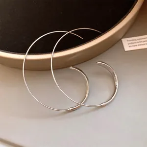 Nahaufnahme von minimalistischen großen silberfarbenen Creolen mit glänzendem Finish