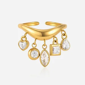 Primo piano di anello a onda in acciaio dorato con cinque ciondoli in zircone multi-forma