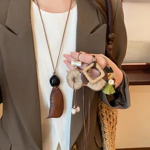 Detail view of retro bohemian wood and rope geometric pendant necklaces.