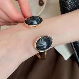 Primo piano di un elegante bracciale a polsino dorato con resina marmorizzata