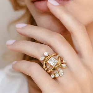 Detailansicht eines vergoldeten Edelstahlrings mit Zirkonia-Quasten und Wellenform.