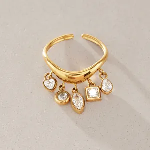 Detailansicht eines goldenen Edelstahl-Wellenrings mit fünf baumelnden Zirkonia-Anhängern