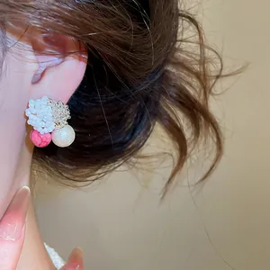 Nahaufnahme der süßen rosa Perlenohrstecker mit Silbernadeln, an einem Ohr gezeigt