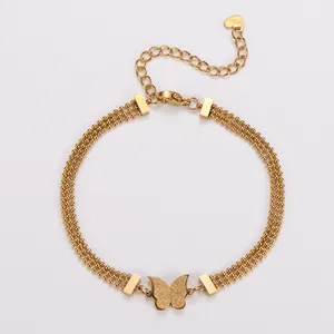 Dettaglio del bracciale a tripla catena in acciaio dorato con farfalla satinata.