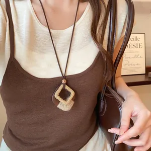 Close-up of a retro wooden geometric pendant necklace styled with a brown camisole.