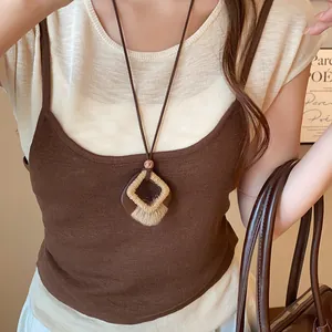 Detail view of a vintage geometric wood and woven pendant necklace worn by a model