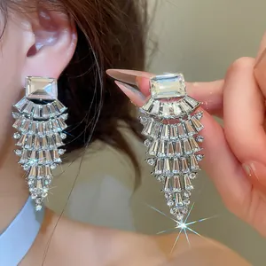 Detailed view of sparkling silver fan-shaped drop earrings with baguette rhinestones