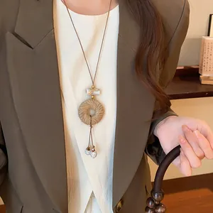 Detailed close-up of a New Chinese retro hemp rope pendant sweater chain on a model