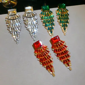 Close-up of fan-shaped dangle earrings with colorful crystals and sparkling finish.