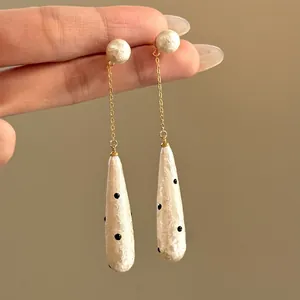 Elegant long drop earrings featuring retro polka dot waterdrop pearls with gold chains.