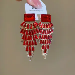 Statement fan-shaped gold-tone drop earrings with vibrant red crystals and silver needles
