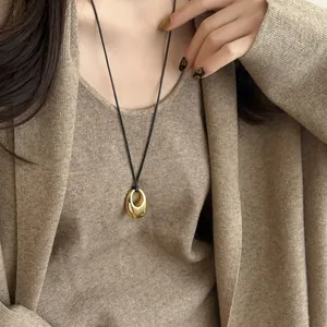 Minimalistische Halskette mit goldenem ovalem Anhänger und schwarzer Kordel für Damen
