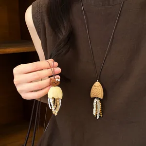 Vue détaillée des pendentifs en bois Hello Kitty et poisson avec glands perlés.