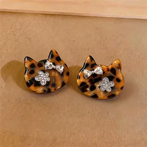 Nahaufnahme von Katzenohrsteckern mit Schildpattmuster und glänzenden Strassdetails.