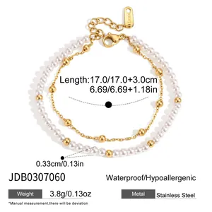 Détail montrant un bracelet double couche en acier inoxydable avec perles blanches