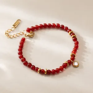 Gros plan d'un bracelet en agate rouge vintage plaqué or 18 carats avec breloque zircon