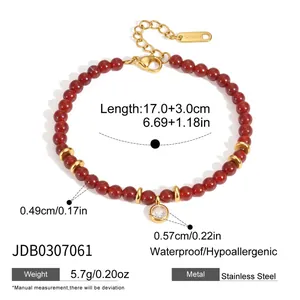 Détail d'un bracelet en perles d'agate rouge avec accessoires en acier inoxydable doré.