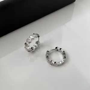 Detail view of silver-plated hoop earrings with hexagonal pattern and embedded zircons.