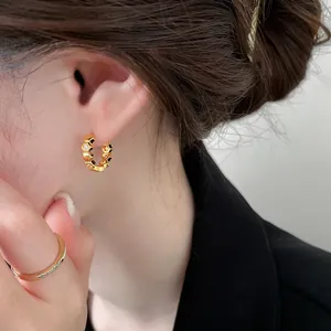 Detailed close-up of 18k gold plated honeycomb hoop earrings with sparkling cubic zirconia