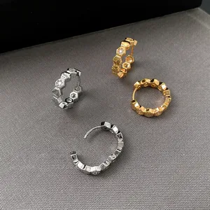 Close-up of 18k gold plated hexagonal hoop earrings with sparkling zircon stones
