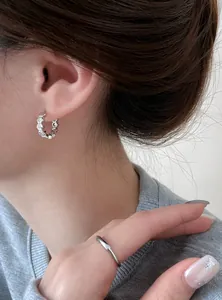 Close-up of elegant 18k gold plated zircon geometric hoop earrings worn by a model
