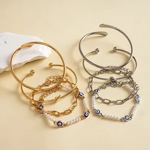 Dettaglio del set di 4 bracciali in metallo con perle, nodi e malocchio portafortuna.