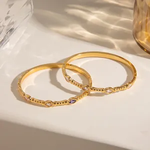 Detail von 18 Karat vergoldeten Edelstahlarmreifen mit bunten ovalen Zirkonia-Inlays
