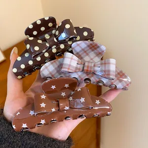 Close-up of retro bow hair claw clips with polka dot, plaid, and star patterns