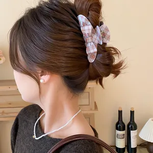 Close-up detail of a vintage brown plaid bow hair claw clip styling an elegant hair updo