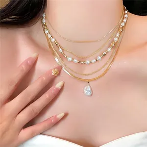 Elegante collana a più strati in catena dorata con raffinati ciondoli in perle