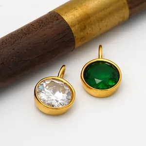 Macro view of emerald green and clear zircon pendants in gold settings