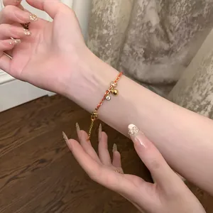 Détail d'un bracelet plaqué or 24K avec des breloques en zircon sur le poignet