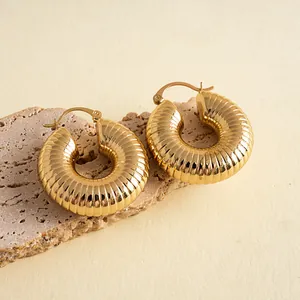 Nahaufnahme goldener gerippter Creolen mit eleganter Struktur und schickem Design