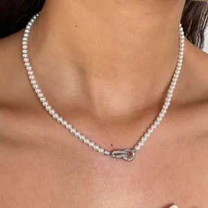 Detailweergave van een parelketting met een pavé gezette in elkaar grijpende gesp