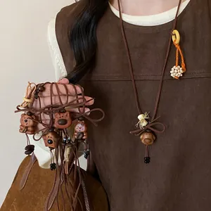 Close-up of cute wooden bear and dog pendant necklaces with brown velvet cords.