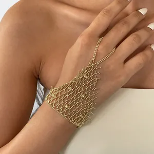 Elegante Nahaufnahme eines goldenen Spinnennetz-Ringarmbands aus Metall an der Hand