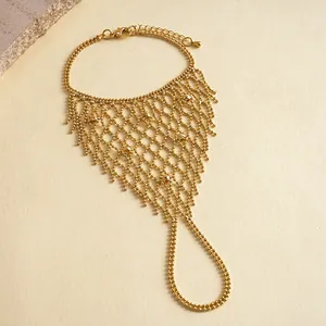Detailansicht eines goldenen Spinnennetz-Armbands mit Perlen-Mesh-Design.