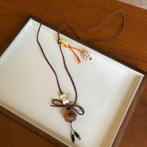 Detailed view of handmade cute wooden dog pendant necklace with brown Korean velvet cord