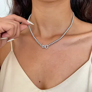 Detail van een elegante zilveren kralenketting met hanger met zirkoon bezette schakel