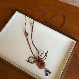Close-up of cute bear pendant necklace with brown Korean velvet cord on display