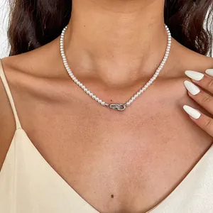 Detailopname van een parelketting met een geometrische sluiting van zirkonia
