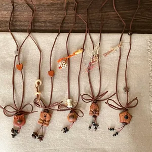 Set of five handmade necklaces with wood and resin animal pendants on brown cords