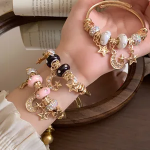 Detaillierte Makroansicht goldener Stern- und Mond-Bettelarmbänder mit bunten Perlen
