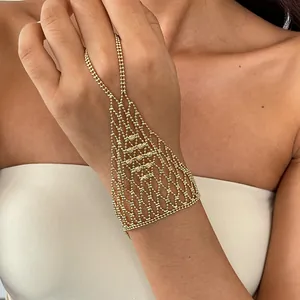 Detailansicht eines goldfarbenen Spinnennetz-Handketten-Armbands mit Ring an einem Modell.