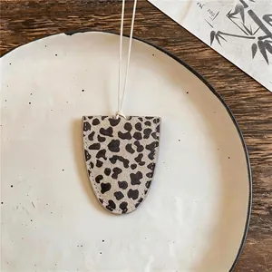 Leopard print leather oval glasses holder pendant necklace on a ceramic plate background